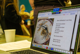 Photo of a laptop displaying an Indigenous drum and poem