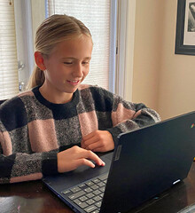 a smiling student using a laptop